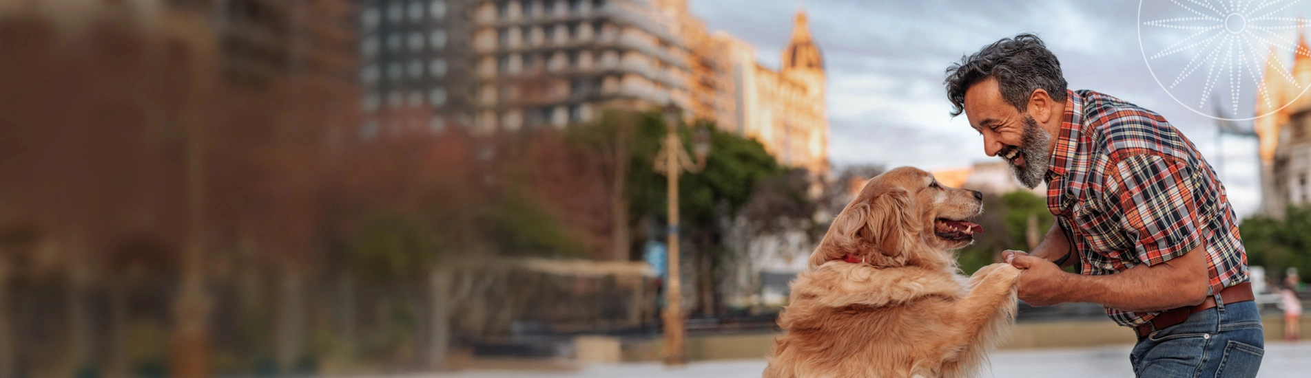 man smiling while holding his dog's paws